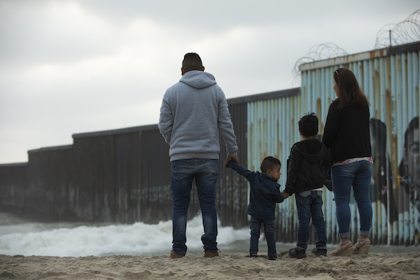 Family with two kids standing at Tijuana border