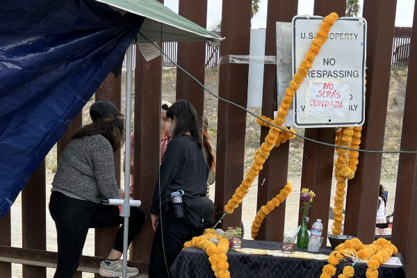 Two women talk to an asylum seeker at an open-air detention site in the Jacumba desert.