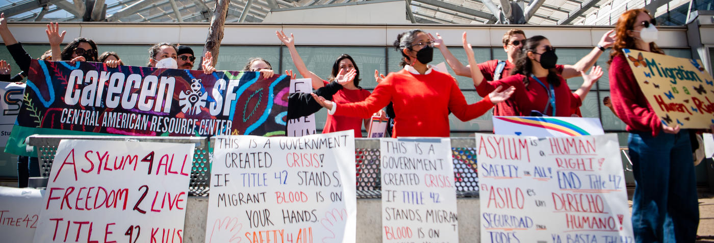 Crowd of CGRS staff members and other protestors holding signs and with open arms.